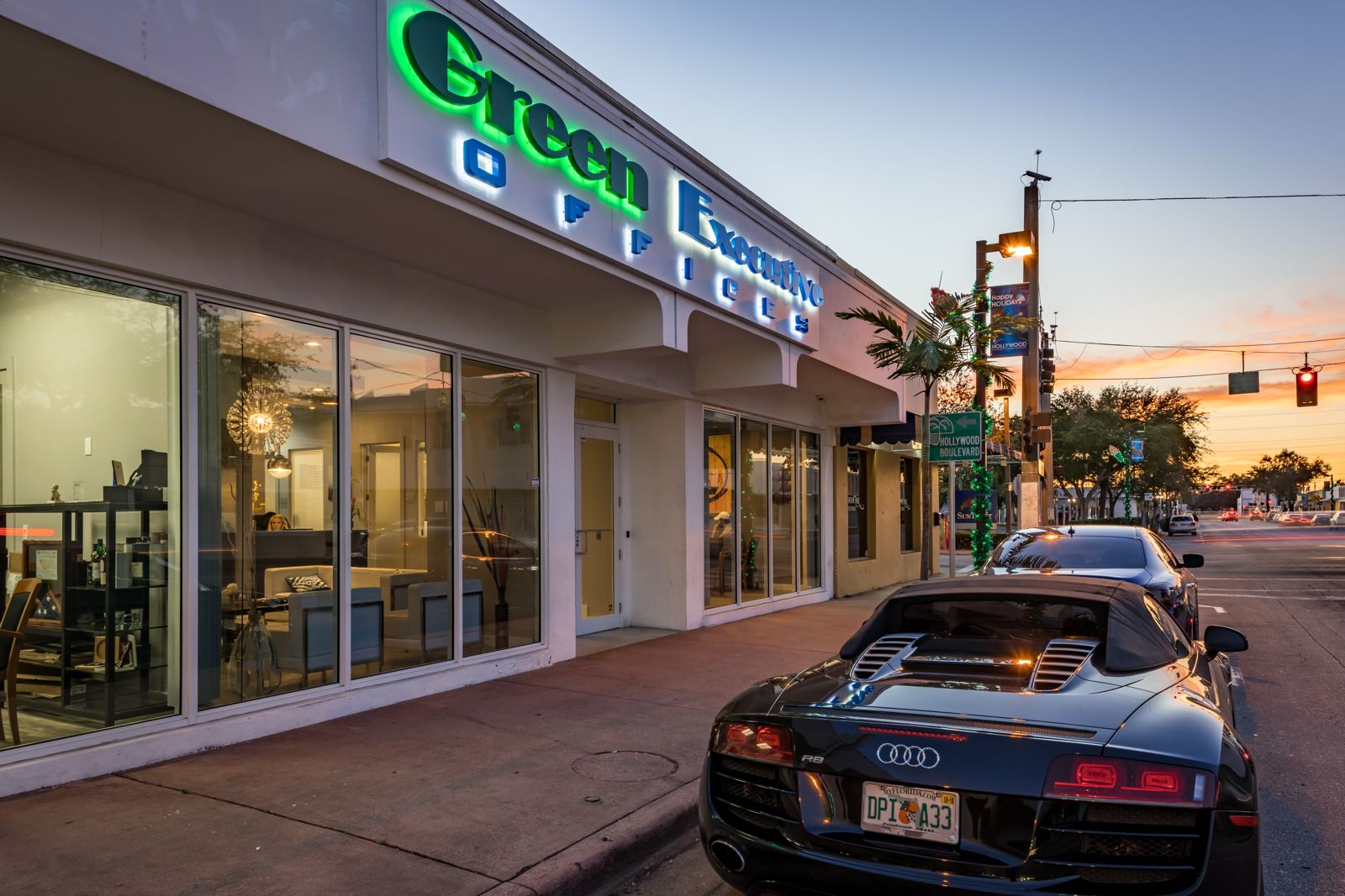 Green Executive Offices storefront on Tyler Street in downtown Hollywood, Florida, at dusk